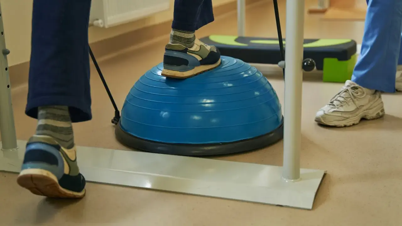 Persona practica ejercicios de equilibrio sobre una pelota azul, una forma de como regular el sistema nervioso y mejorar la coordinación.