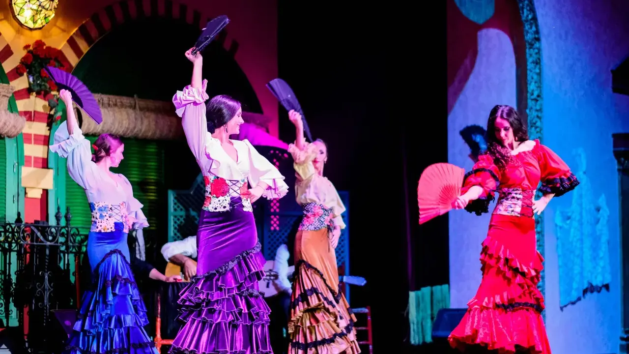 Bailarinas de flamenco con abanicos desplegados, mostrando las partes de un abanico en un espectáculo vibrante.