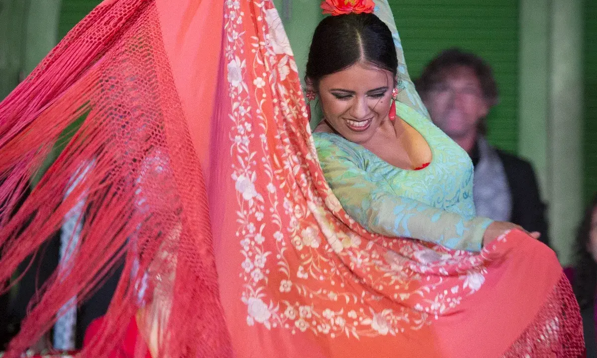 Bailarina flamenca con mantón de Manila, su movimiento evoca la rica historia del mantón de Manila.