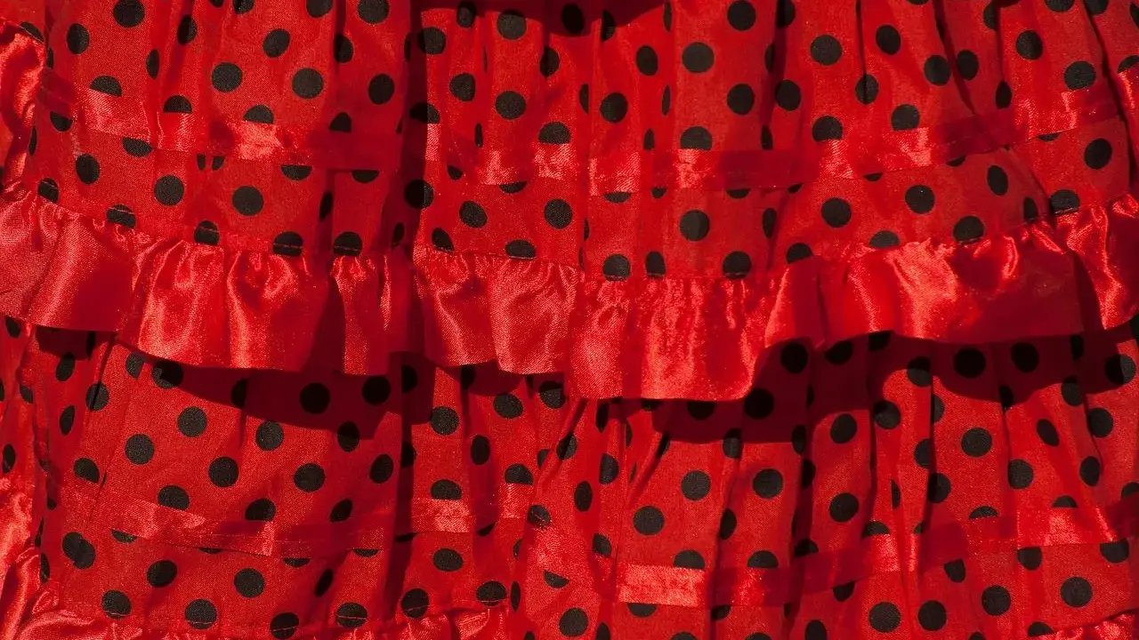 Falda roja con lunares negros, con volantes y cintas, ideal para un baile típico de Sevilla.