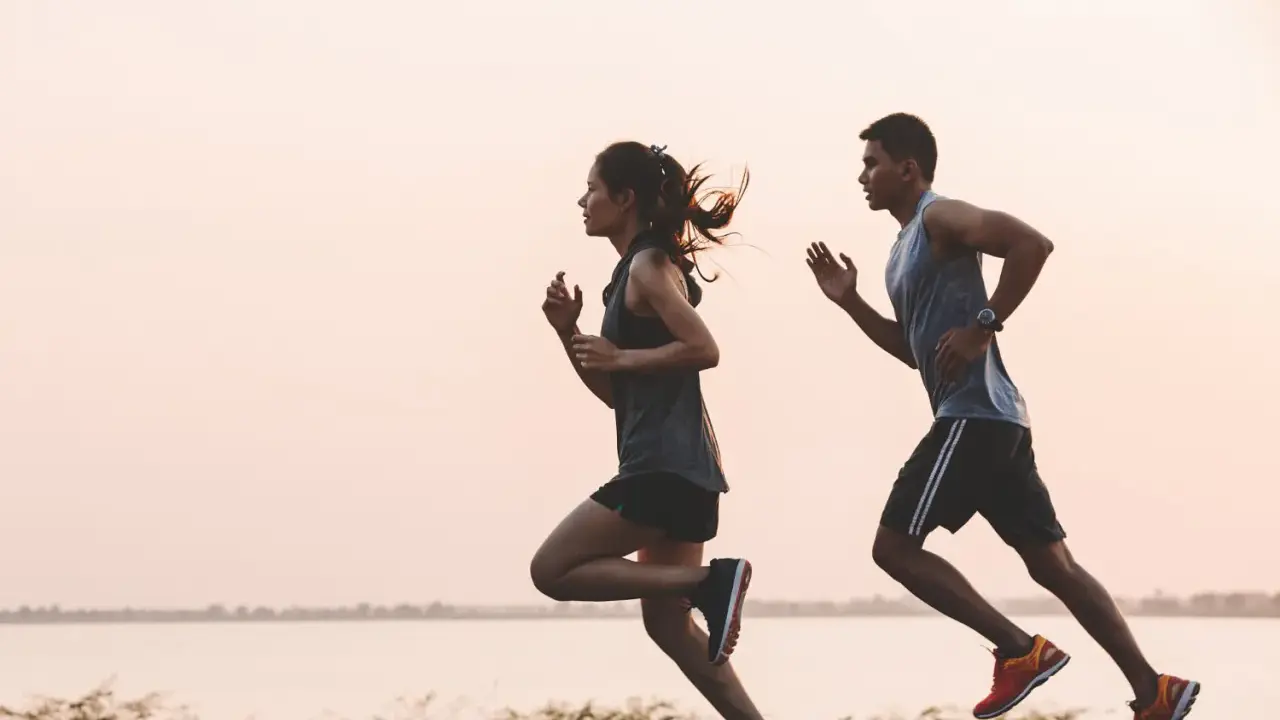 Pareja corriendo al amanecer. Un recordatorio de cuando tomar electrolitos para rehidratarse y mantener la energía.