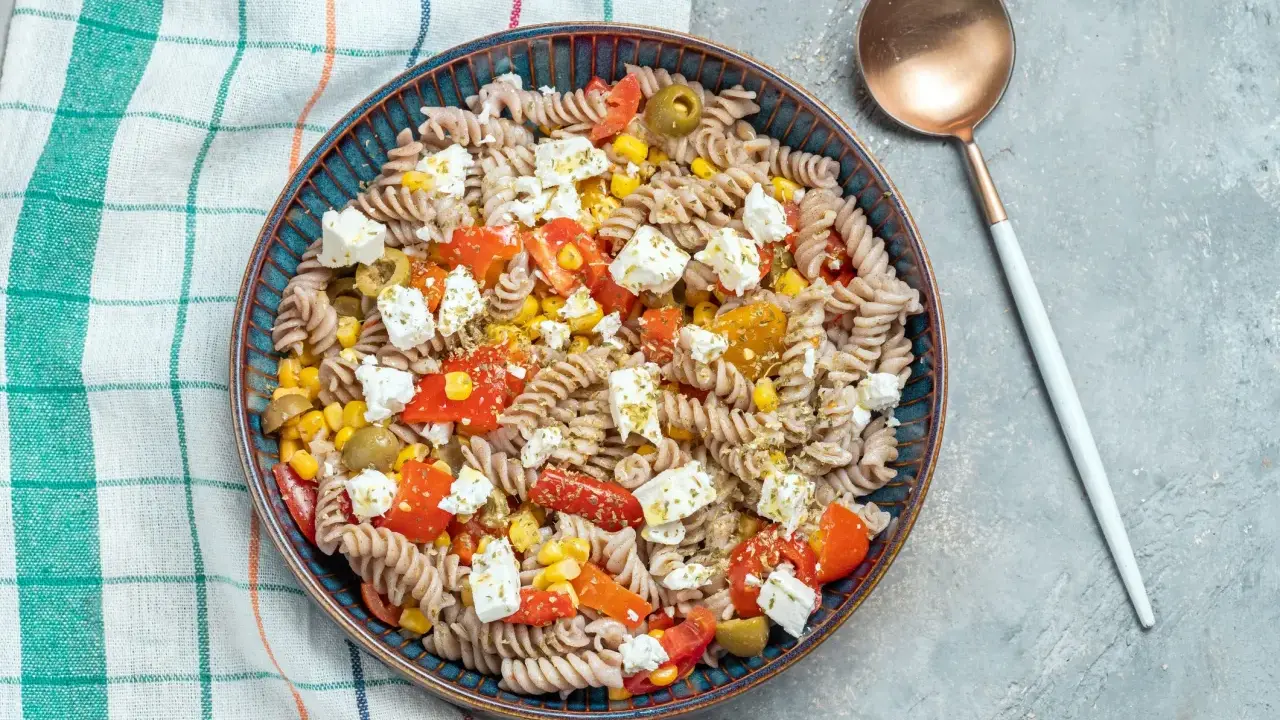 Ensalada de pasta fit con fusilli integral, tomate, maíz, aceitunas y queso feta. Un plato ligero y sabroso.
