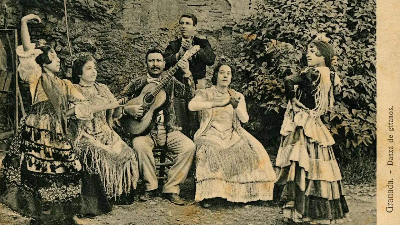 Grupo de músicos y bailarinas, una de ellas realiza un zambra baile gitano, con guitarras y mantones.