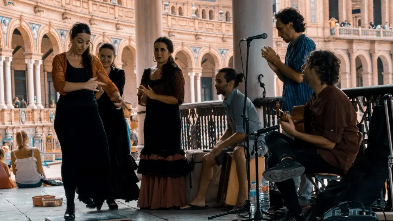 Artistas flamencos crean un jaleo de música y baile en una plaza.