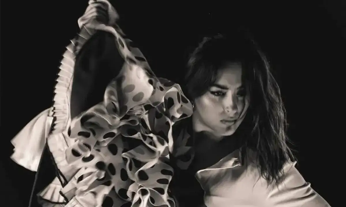 Bailaora flamenca famosa con volantes de lunares, capturada en un momento de intensa expresión artística.