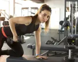 Adolescente de 15 años realizando rutinas de gimnasio con pesas.