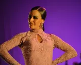 Bailaora de flamenco, con un vestido de encaje rosa, interpreta una seguiriya con pasión bajo luces púrpuras.