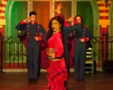 Una bailaora de flamenco con un vestido rojo vibrante, rodeada por dos hombres con uniformes militares, capturando la esencia de las alegrías flamenco.