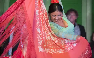 Bailarina flamenca con mantón de Manila, su movimiento evoca la rica historia del mantón de Manila.