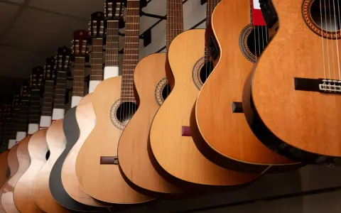 Varias guitarras cuelgan en fila, mostrando la diferencia entre guitarra española y flamenca.