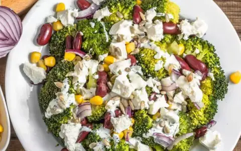 Ensalada de brócoli con frijoles rojos, maíz, queso feta y cebolla morada. Unos de los ejemplos de menús saludables y coloridos.