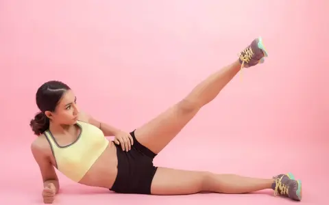 Mujer haciendo ejercicio, levantando una pierna para trabajar el **parte interna del muslo**.