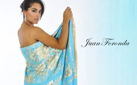 Mujer con mantón de Manila azul turquesa con bordados dorados, mostrando cómo colocar un mantón de manila como vestido.