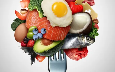 Un tenedor carga una variedad de alimentos saludables, incluyendo salmón, aguacate, huevo, bayas y verduras bajas en carbohidratos, ideal para una dieta equilibrada.