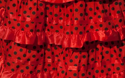 Falda roja con lunares negros, con volantes y cintas, ideal para un baile típico de Sevilla.