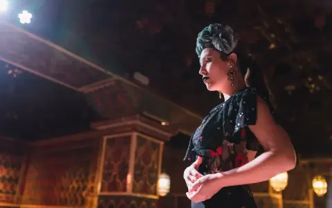 Una bailaora, con flor en el pelo y labios oscuros, encarna la pasión y el duende que qu'exprime le flamenco.