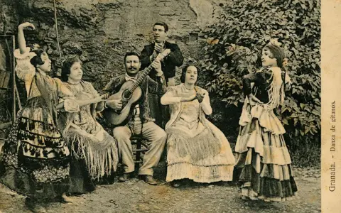 Grupo de músicos y bailarinas, una de ellas realiza un zambra baile gitano, con guitarras y mantones.