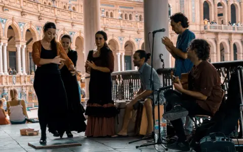 Artistas flamencos crean un jaleo de música y baile en una plaza.