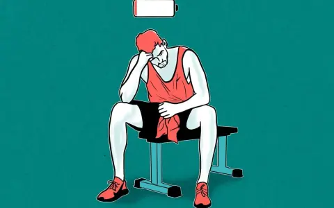 Un hombre agotado sentado con una barra de batería baja encima. Esto ilustra qué pasa si no menges proteines.