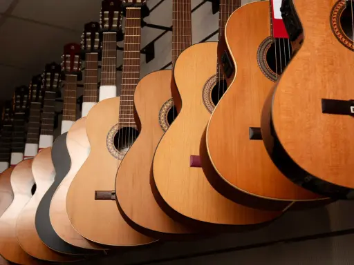 Varias guitarras cuelgan en fila, mostrando la diferencia entre guitarra española y flamenca.