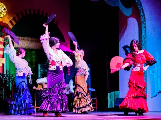 Bailarinas de flamenco con abanicos desplegados, mostrando las partes de un abanico en un espectáculo vibrante.