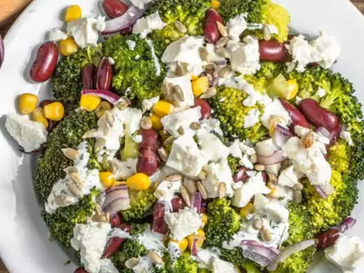 Ensalada de brócoli con frijoles rojos, maíz, queso feta y cebolla morada. Unos de los ejemplos de menús saludables y coloridos.