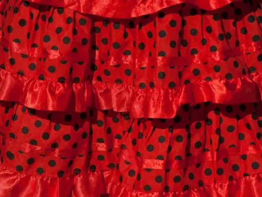 Falda roja con lunares negros, con volantes y cintas, ideal para un baile típico de Sevilla.