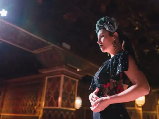 Una bailaora, con flor en el pelo y labios oscuros, encarna la pasión y el duende que qu'exprime le flamenco.