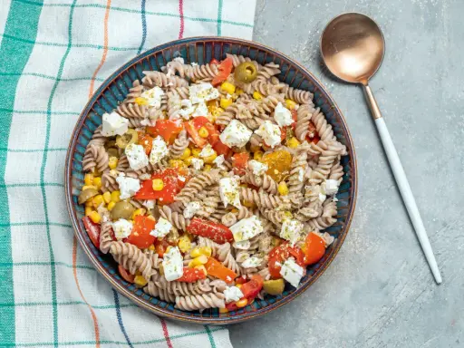 Ensalada de pasta fit con fusilli integral, tomate, maíz, aceitunas y queso feta. Un plato ligero y sabroso.