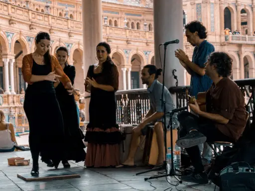 Artistas flamencos crean un jaleo de música y baile en una plaza.