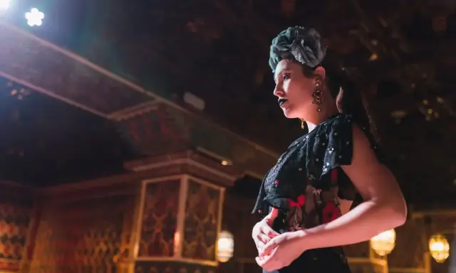 Una bailaora, con flor en el pelo y labios oscuros, encarna la pasión y el duende que qu'exprime le flamenco.