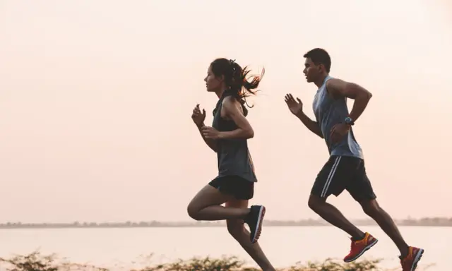 Pareja corriendo al amanecer. Un recordatorio de cuando tomar electrolitos para rehidratarse y mantener la energía.