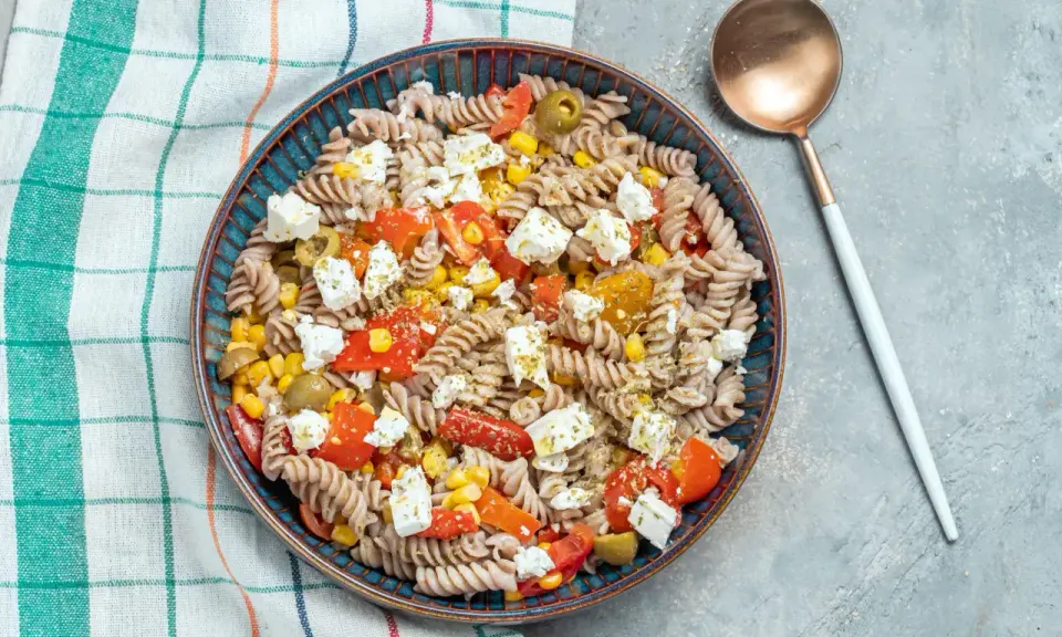 Ensalada de pasta fit con fusilli integral, tomate, maíz, aceitunas y queso feta. Un plato ligero y sabroso.