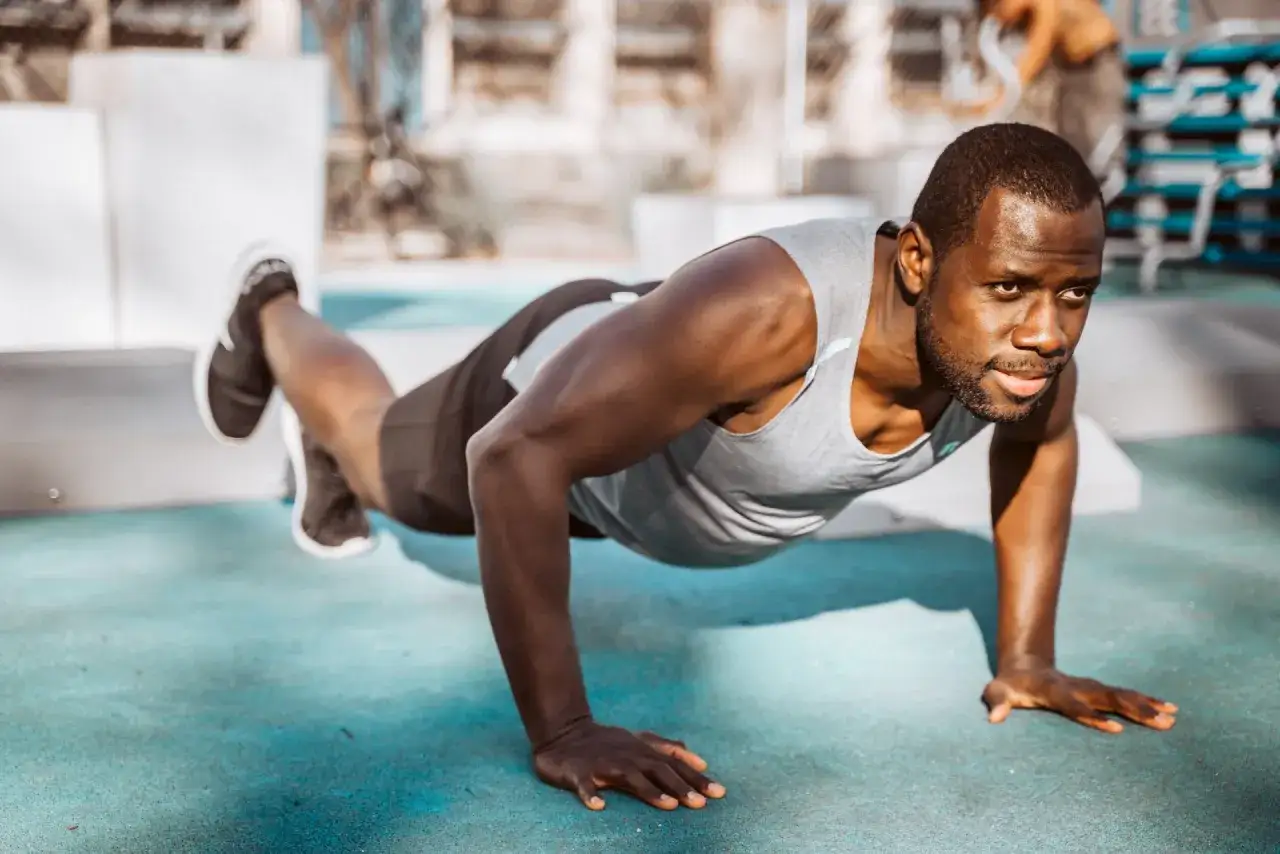 Hombre haciendo flexiones, un ejercicio clave para saber como hacer una rutina de gym.
