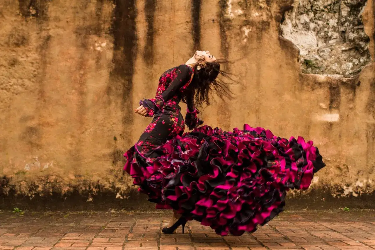 Una bailaora de flamenco, con su vestido volando, expresa la pasión y el alma del flamenco dance meaning.