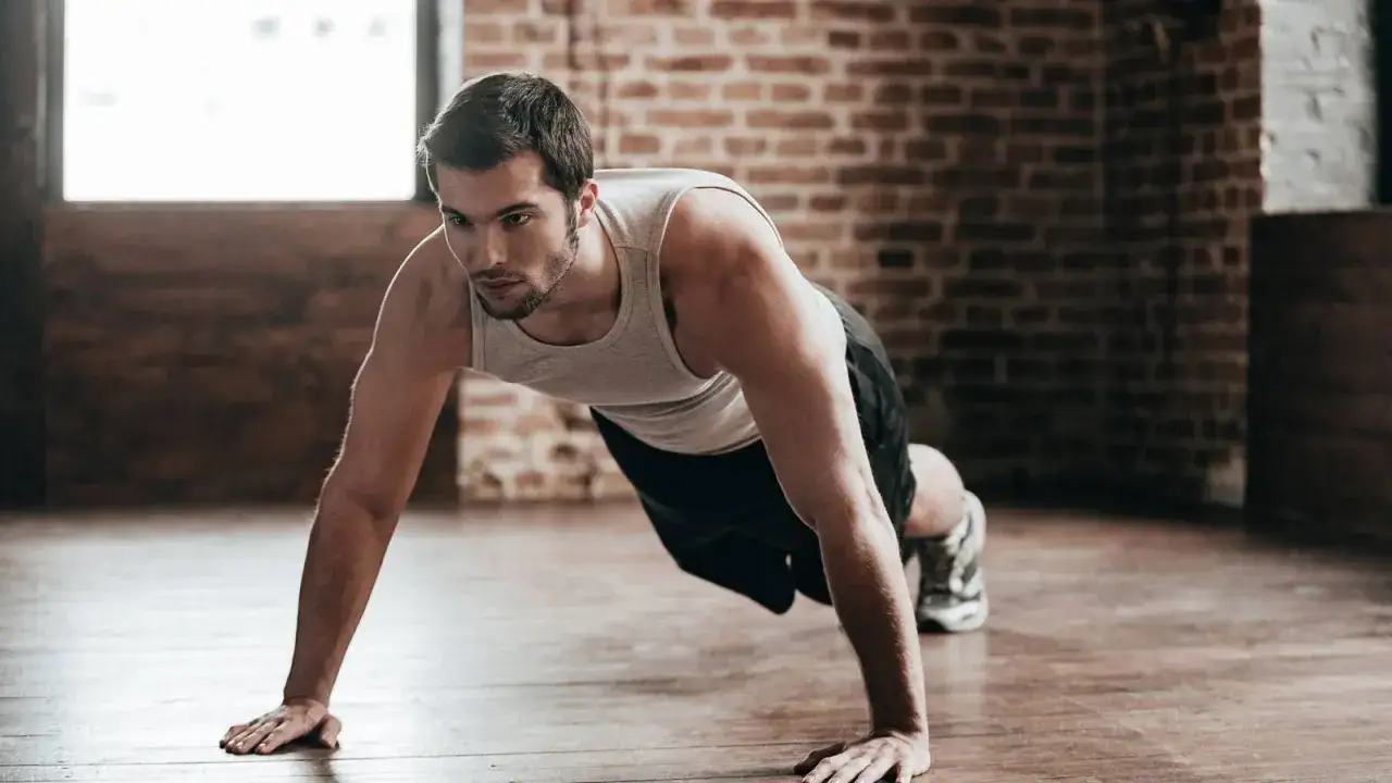 Hombre haciendo flexiones, parte de su rutina de liss cardio.