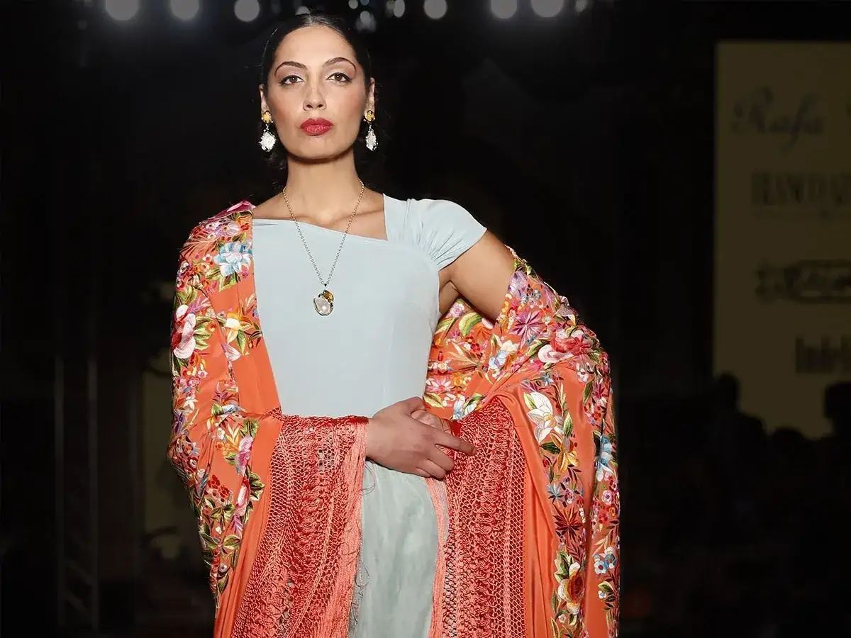 Modelo luce un mant&oacute;n de Manila con flores como vestido, mostrando c&oacute;mo colocarlo elegantemente.