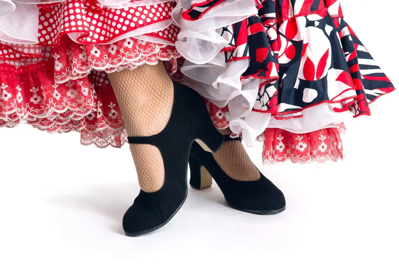 Detalle de bailadores flamencos hombres con volantes rojos y negros, medias de rejilla y zapatos negros de tac&oacute;n.