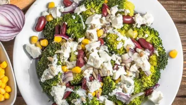 Ensalada de brócoli con frijoles rojos, maíz, queso feta y cebolla morada. Unos de los ejemplos de menús saludables y coloridos.
