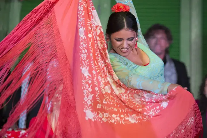 Bailarina flamenca con mantón de Manila, su movimiento evoca la rica historia del mantón de Manila.